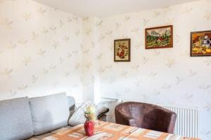 a dining room with a table and a couch at Haus am Candelaber in Altenbergen