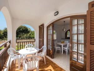 a room with a balcony with tables and chairs at Girasol Garden Superior 2-d in Menorca