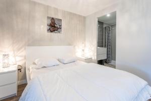 a white bedroom with a large white bed and a mirror at Superbe F2 Spacieux - Saint Raphael in Saint-Raphaël +13 photos