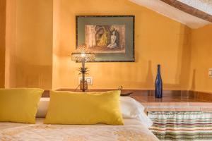 a bedroom with yellow walls and a bed with yellow pillows at Tomillo in Hinojares