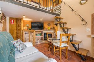 a living room with a staircase and a table and chairs at Tomillo in Hinojares