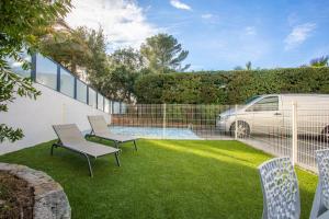 a yard with chairs and a fence and a car at Superbe F2 Spacieux - Saint Raphael in Saint-Raphaël