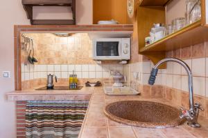 a kitchen with a sink and a microwave at Tomillo in Hinojares +24 photos