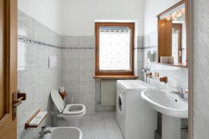 a white bathroom with a sink and a toilet at Residence Malibu Appartamento 4 in Falcade +19 photos