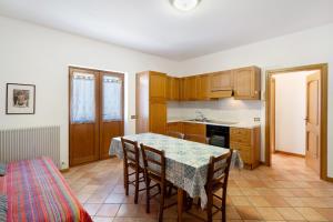 a kitchen with a table and chairs in a room at Residence Malibu Appartamento 4 in Falcade