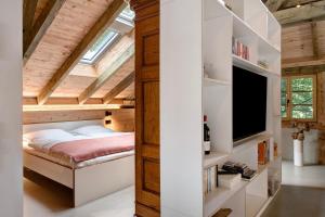 a bedroom in a loft with a bed and a tv at Ferienwohnung im Gehöft in Müllheim