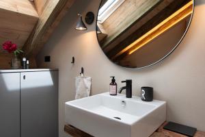 a bathroom with a white sink and a mirror at Ferienwohnung im Gehöft in Müllheim +20 photos