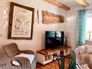 a living room with a television and a chair at Ferienhaus am Rande des Spreewald in Heinersbrück +5 photos