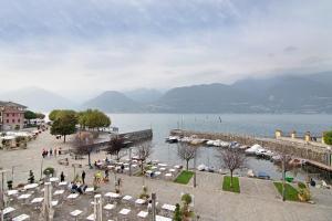 a large body of water with a group of tables and chairs at Greta House in Colico
