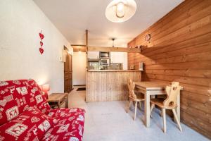 a living room with a red couch and a table at Studio Chatel - Au pieds du Linga in Châtel +11 photos