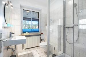 a bathroom with a shower and a toilet and a sink at Haus Wacholder in Undeloh +65 photos