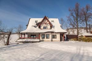 a house with a snow covered roof in the snow at Quality House - Cisza nad Doliną in Zakopane