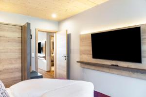 a bedroom with a flat screen tv on a wall at Apartment Steinbock in Pflach