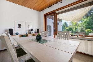 a dining room table with a vase on it at Die Kleine Ferienvilla in Wesselburen