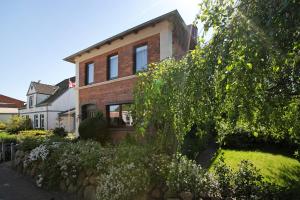 a brick house with a stone wall at Die Kleine Ferienvilla in Wesselburen