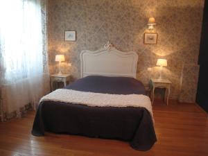 a bedroom with a bed with two tables and two lamps at Les Charmilles in Charny-sur-Meuse
