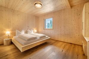 a bedroom with a bed in a wooden wall at Naturapartments Alpreid Fichte in San Pancrazio dʼUltimo