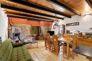a living room with a green couch and a dining room at Quinta das Cavadas in Canedo