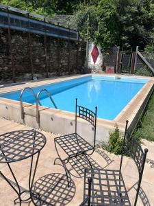 a swimming pool with two chairs and a table at Quinta das Cavadas in Canedo