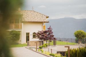 a white house with a fence in front of it at Valentinerhof Apt Aqua in San Michele