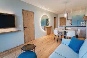 a living room with a blue couch and a table at Valentinerhof Apt Aqua in San Michele