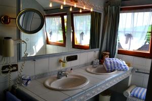 a bathroom with two sinks and a mirror at Haus Bachschwalbe in Sasbachwalden +65 photos