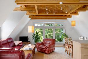 a living room with leather chairs and a table at Wellness Ferienwohnung Müller in Rostock