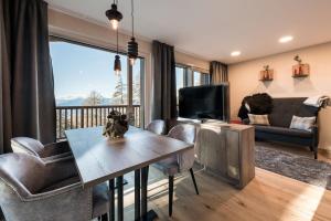 a living room with a table and chairs and a television at Piz Aich Natur Chalet Panorama in Avelengo