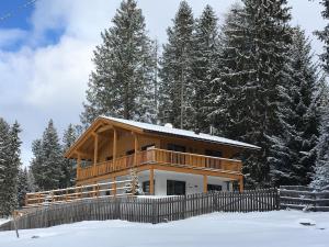 a house in the snow with a fence at Piz Aich Natur Chalet Panorama in Avelengo +2 photos