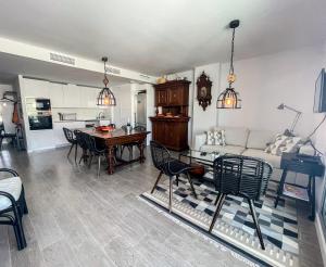 a living room with a couch and a table and chairs at Atico Bremadito in Torrox Costa +7 photos