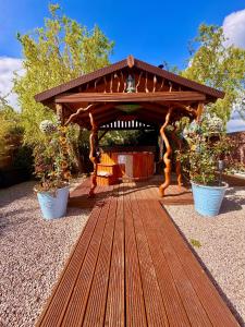 a wooden gazebo with two plants in pots at Alices Garden Two in York +19 photos