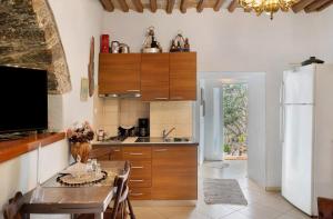 a kitchen with a table and a refrigerator at Maria in the castle Kea in Ioulis