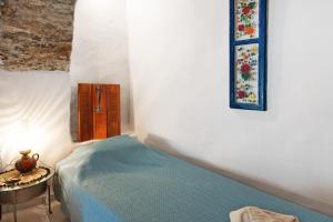 a bedroom with a bed and a table with a picture on the wall at Maria in the castle Kea in Ioulis