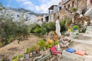 a patio with chairs and an umbrella and plants at Maria in the castle Kea in Ioulis