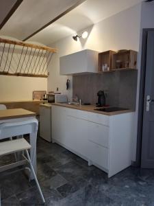 a kitchen with white cabinets and a counter top at Côté Cour in Rasteau