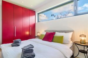 a bedroom with red cabinets and a white bed at Design Apartment Mettnaublick in Radolfzell am Bodensee
