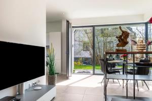 a living room with a tv and a table with chairs at Design Apartment Mettnaublick in Radolfzell am Bodensee