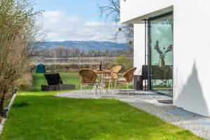 a patio with chairs and a table in the grass at Design Apartment Mettnaublick in Radolfzell am Bodensee