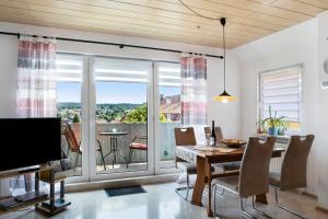 a dining room with a table and a large window at Ferienwohnung Vierheller in Lauterbach
