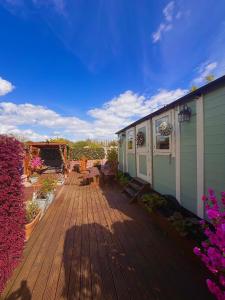 a wooden deck with flowers and a house at Alices Garden Two in York
