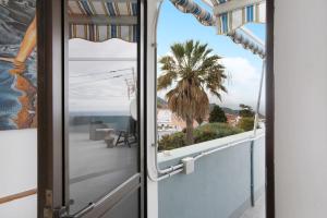 an open door to a balcony with a palm tree at La Zotea in Tegueste