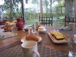 a wooden table with pastries and coffee cups on it at Les Charmilles in Charny-sur-Meuse +45 photos