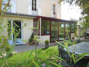 a screened in porch of a house with a table at Les Charmilles in Charny-sur-Meuse