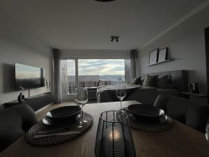 a living room with a table with two wine glasses at Black Forest Home in Schönwald
