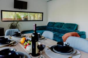 a living room with a table with a bottle of wine at Domki nad Krasnem in Krasne
