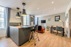 a kitchen and living room with a table and chairs at Appartement du Théâtre Morlaix in Morlaix