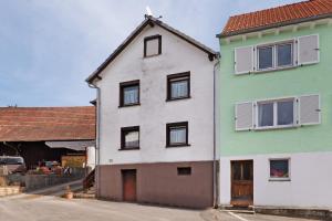 ein weißes Haus mit schwarzen Fenstern in einer Straße in der Unterkunft Brown in Bad König
