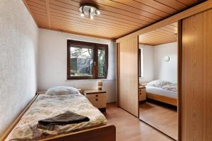 ein kleines Schlafzimmer mit einem Bett und einem Spiegel in der Unterkunft Brown in Bad König