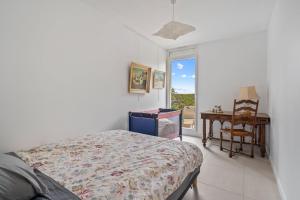 a bedroom with a bed and a desk and a window at Terrasse de Malissol in Vienne