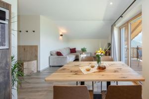 a dining room with a table and a couch at Furnerhof Apt Stearnzauber in Collepietra